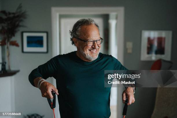 happy active senior man exercising with resistance band at home - home workout stock pictures, royalty-free photos & images