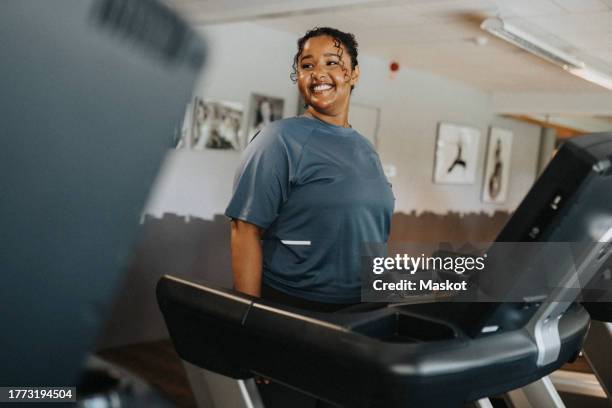 happy young woman exercising on treadmill at health club - ejercicio-cardiovascular fotografías e imágenes de stock
