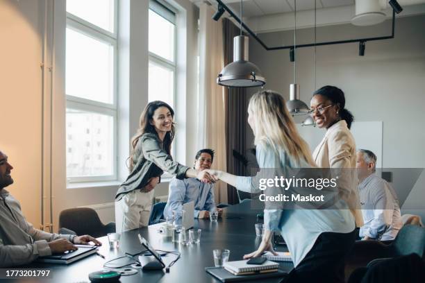 smiling businesswoman shaking hand and greets client during meeting in office - welcome fotografías e imágenes de stock