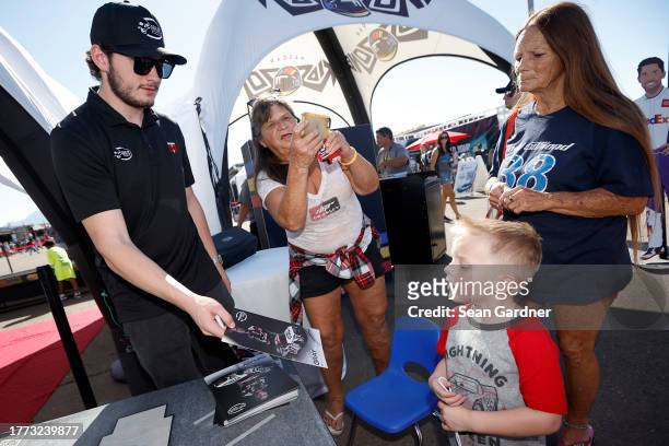 Craftsman Truck Series driver, Taylor Gray interacts with a young NASCAR fan during an appearance at the NASCAR Kids Zone on the midway at Phoenix...
