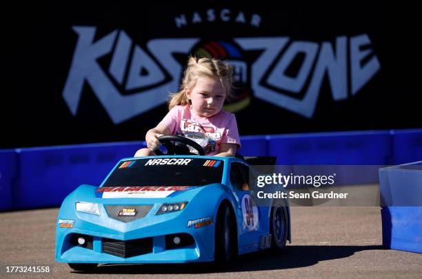 Young NASCAR fan drives a toy car at the NASCAR Kids Zone on the midway at Phoenix Raceway on November 03, 2023 in Avondale, Arizona.