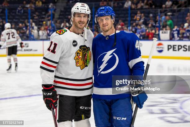 Brothers Darren Raddysh of the Tampa Bay Lightning and Taylor Raddysh of the Chicago Blackhawks during the pregame warm ups at Amalie Arena on...