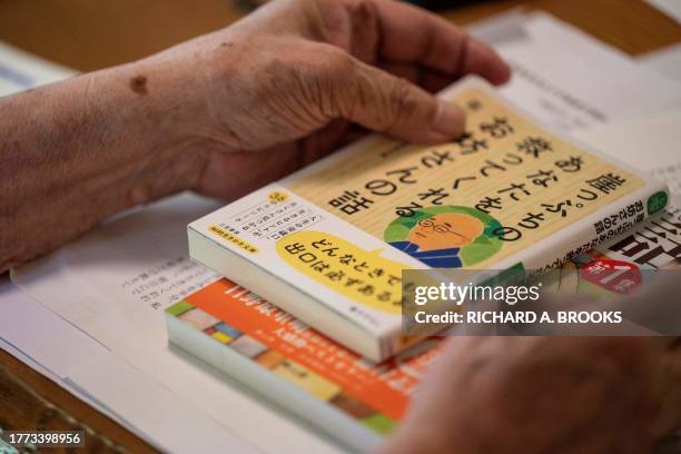 This photo taken on September 5, 2023 shows chief Buddhist priest Eiichi Shinohara displaying books he has written, during an interview with AFP at...