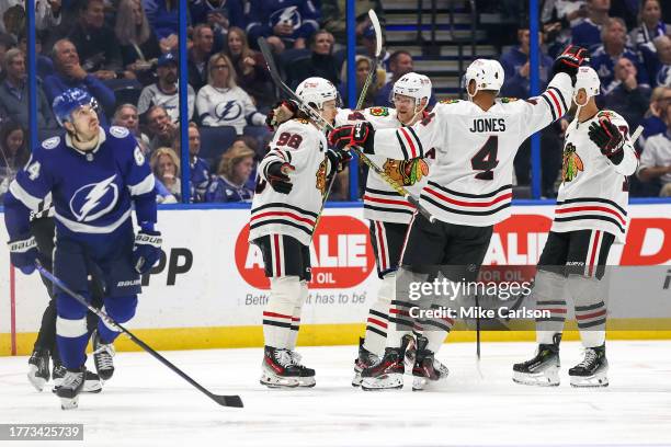 Corey Perry of the Chicago Blackhawks, second from left, celebrates his goal with Connor Bedard, and Seth Jones as Tyler Motte of the Tampa Bay...