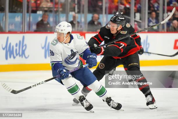 Brady Tkachuk of the Ottawa Senators battles for position against Andrei Kuzmenko of the Vancouver Canucks at Canadian Tire Centre on November 9,...