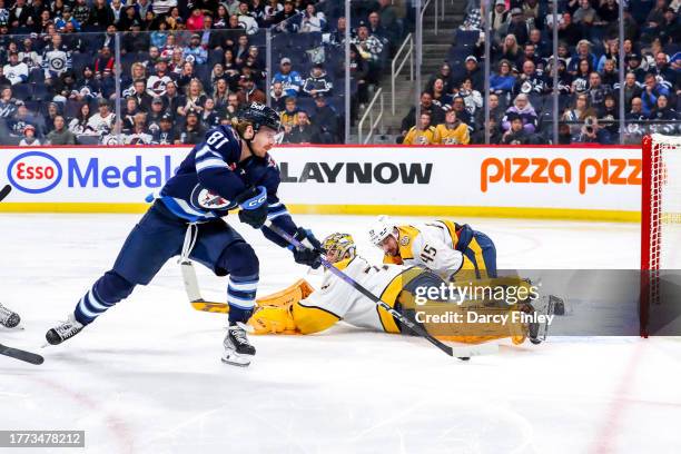 Kyle Connor of the Winnipeg Jets plays the puck around a sprawling Juuse Saros of the Nashville Predators during second period action at the Canada...