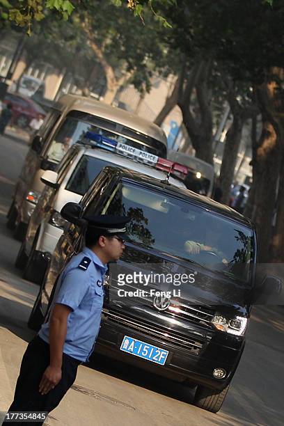 The police car transporting former Chinese politician Bo Xilai arrives at the Jinan Intermediate People's Court on August 23, 2013 in Jinan, China....