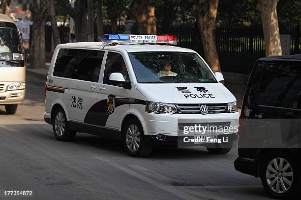 The police car transporting former Chinese politician Bo Xilai arrives at the Jinan Intermediate People's Court on August 23, 2013 in Jinan, China....