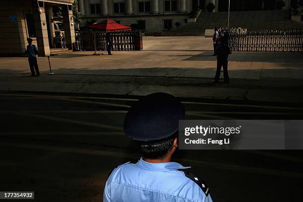 Chinese policemen guard outside the gate of the Jinan Intermediate People's Court on August 23, 2013 in Jinan, China. Ousted Chinese politician Bo...
