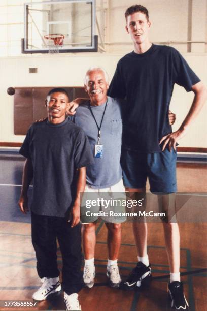 Tyrone Curtis "Muggsy" Bogues of the Charlotte Hornets who is wearing Reebok shoes, Austin McCann and Shawn Bradley of the New Jersey Nets who are...
