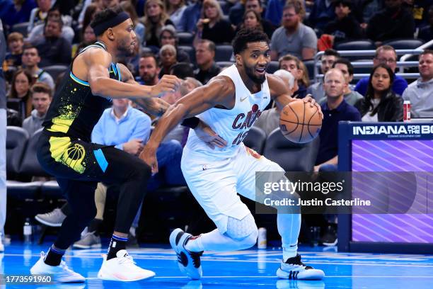 Donovan Mitchell of the Cleveland Cavaliers brings the ball up the court while defended by Bruce Brown of the Indiana Pacers during the first half...