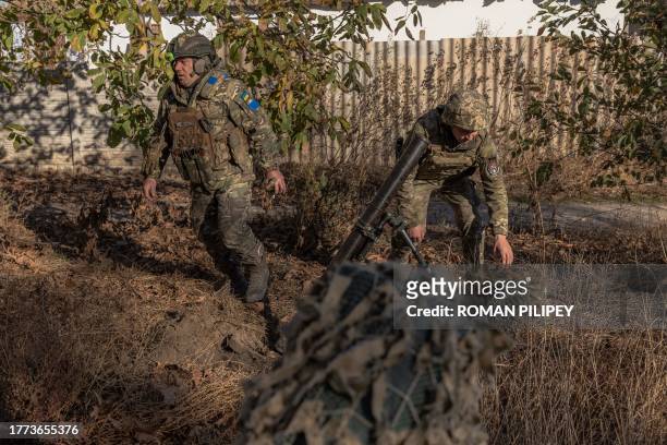 Ukrainian servicemen of the 123rd Territorial Defense Brigade in action while firing a mortar over the Dnipro River toward Russian positions, in an...