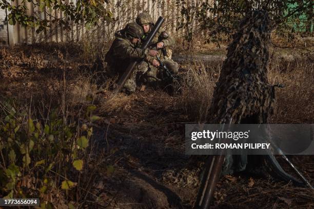 Ukrainian servicemen of the 123rd Territorial Defense Brigade prepare to fire a mortar over the Dnipro River toward Russian positions, in an...