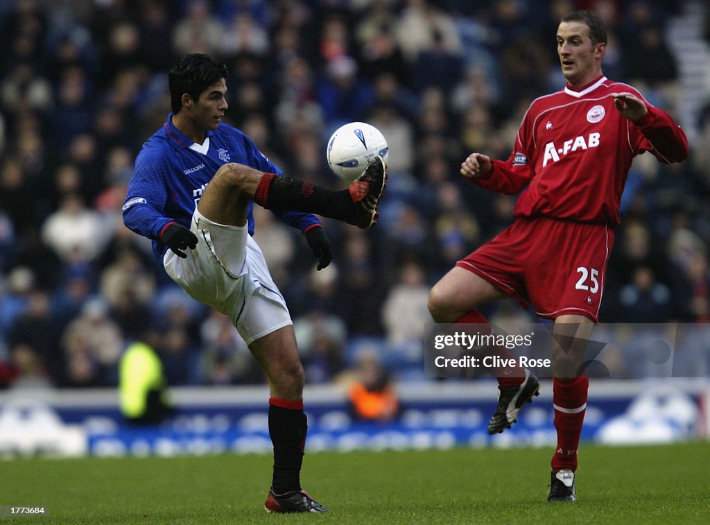 Mikel Arteta of Glasgow Rangers lifts the ball over the head of Paul