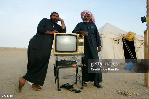 Campers in the desert of Kuwait pack up the television from inside their tent as they dismantle it February 10, 2003 north of Kuwait City, Kuwait....