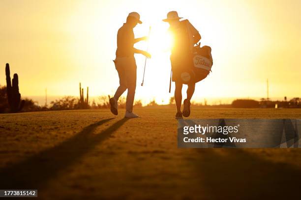 Brandon Wu of the United States hands his caddie a club on the ninth green during the second round of the World Wide Technology Championship at El...