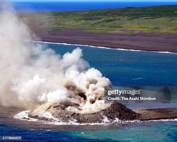 In this aerial image, earth and sand are sent into the air above a new islet off the coast of Iwoto island on November 3, 2023 in Ogasawara, Tokyo,...