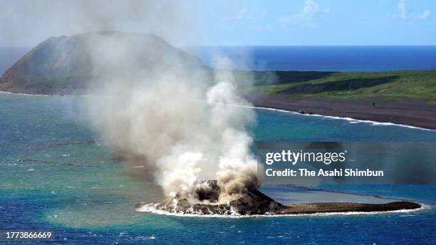 In this aerial image, earth and sand are sent into the air above a new islet off the coast of Iwoto island on November 3, 2023 in Ogasawara, Tokyo,...