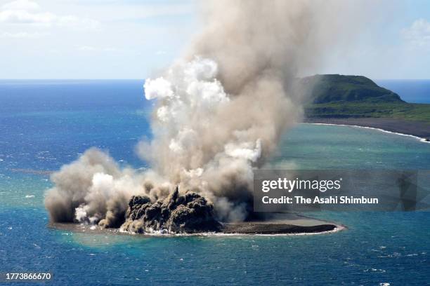 In this aerial image, earth and sand are sent into the air above a new islet off the coast of Iwoto island on November 3, 2023 in Ogasawara, Tokyo,...