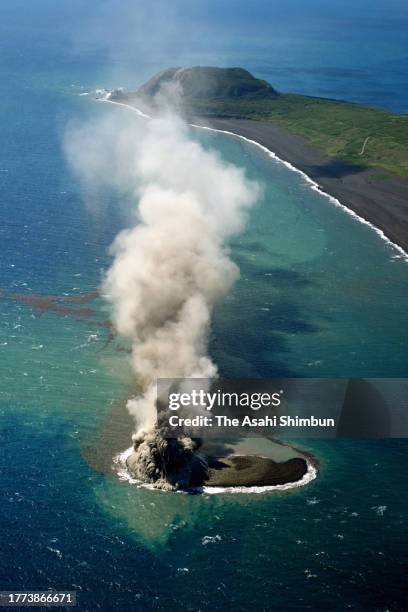 In this aerial image, earth and sand are sent into the air above a new islet off the coast of Iwoto island on November 3, 2023 in Ogasawara, Tokyo,...