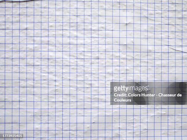 close-up of a sheet of graph paper glued together and on a textured wall in paris - graph paper stock pictures, royalty-free photos & images
