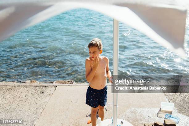 sunscreen ritual by the sea - belly rub stockfoto's en -beelden