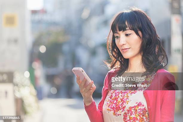 woman holding mobile phone - west asia stock-fotos und bilder