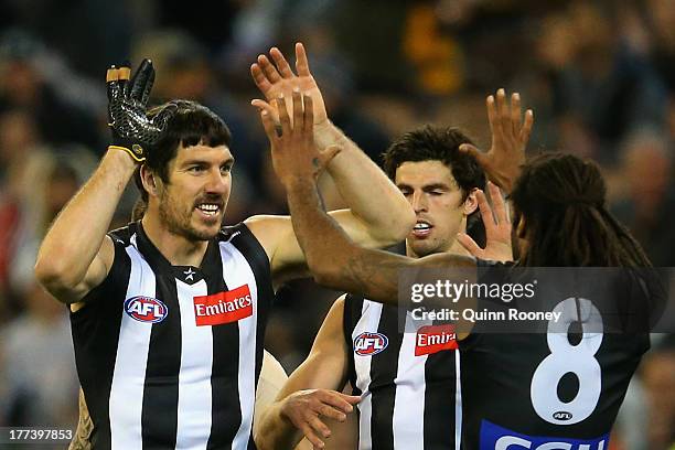 Quinten Lynch of the Magpies is congratulated by Harry O'Brien after kicking a goal during the round 22 AFL match between the Collingwood Magpies and...