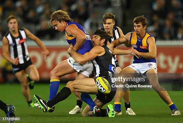 Matt Priddis of the Eagles is tackled by Quinten Lynch of the Magpies during the round 22 AFL match between the Collingwood Magpies and the West...