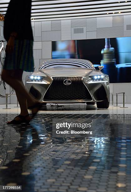 Woman walks past Toyota Motor Corp.'s Lexus LF-CC concept car on display at the "Intersect by Lexus" luxury brand experience space in Tokyo, Japan,...