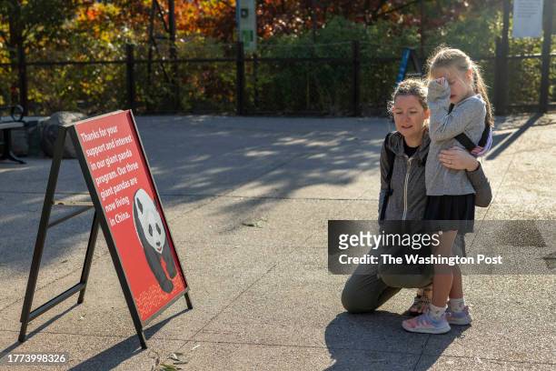 Meghan Linden consoles her six-year-old daughter Harper Linden as they read a sign about the panda's relocation to China at the Smithsonian National...