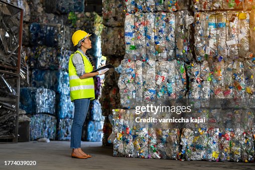 Female worker checks the stock and controls the separation of recyclable waste of the plastic waste recycling plant. And other types of waste, the concept of recycling. Female worker checks the stock and controls the separation of recyclable waste of the plastic waste recycling plant. And other types of waste, the concept of recycling.