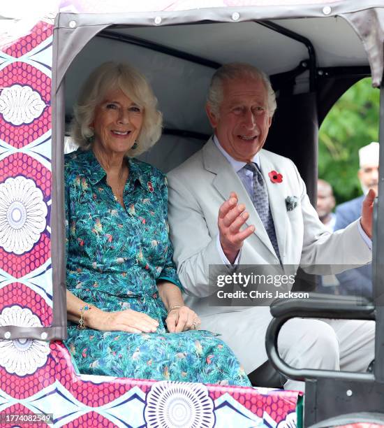 Queen Camilla and King Charles III smile as they sit in an electric tuk-tuk during a visit to Fort Jesus, the UNESCO World Heritage Site, where they...