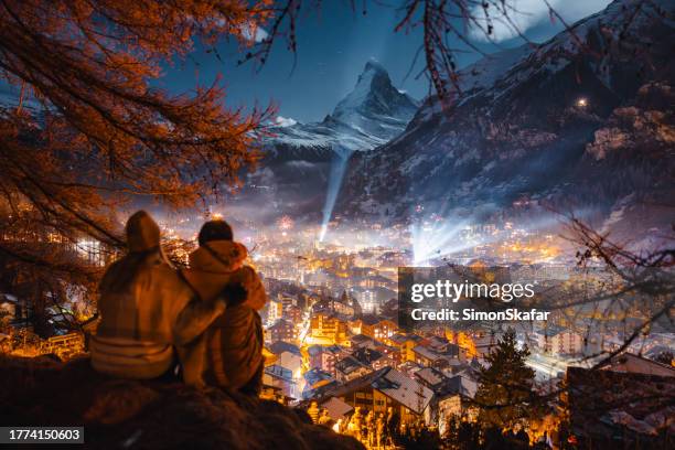 romantisches junges paar mit blick auf zermatt und den matterhorngipfel in der winternacht - zermatt stock-fotos und bilder