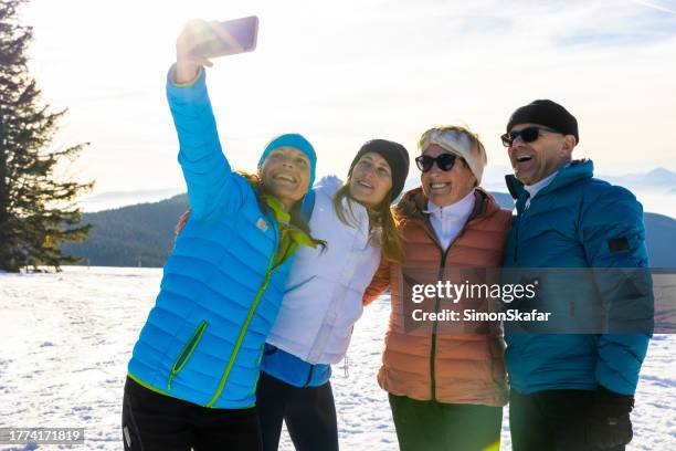 happy family in warm clothing taking selfie using mobile phone during winter holiday - travels with my father photocall stock pictures, royalty-free photos & images