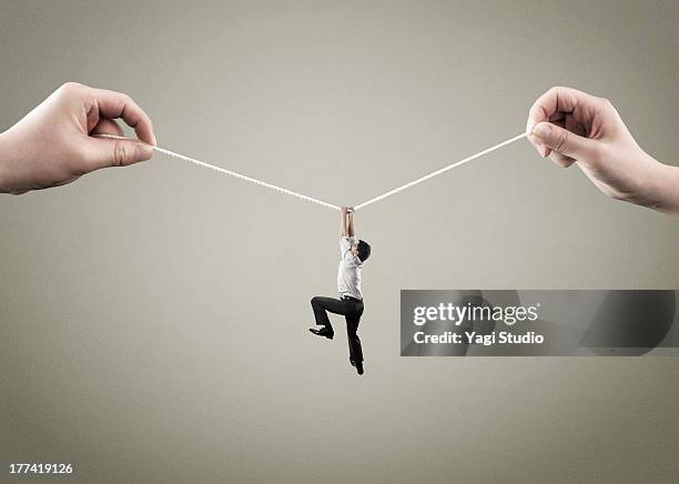 man hold on to rope - draped stockfoto's en -beelden