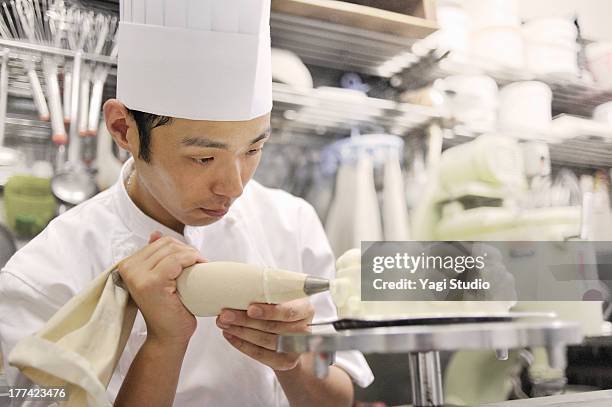 pastry chef decorating cake - decorating a cake fotografías e imágenes de stock
