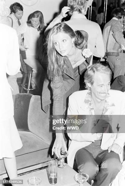 Apollonia van Ravenstein and John Phillips attend a party at On the Rox, a nightclub in West Hollywood, California, on July 28, 1975.