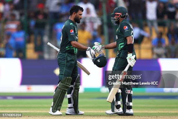 Fakhar Zaman of Pakistan celebrates their century with team mate Babar Azam during the ICC Men's Cricket World Cup India 2023 between New Zealand and...