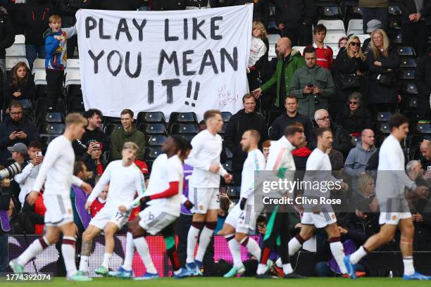 Fans of Manchester United hold up a banner reading "Play like you mean it" as the team warms up prior to the Premier League match between Fulham FC...