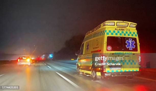 an ambulance navigating a danish highway at night - danish culture stock pictures, royalty-free photos & images