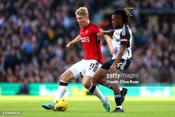 Rasmus Hojlund of Manchester United is challenged by Alex Iwobi of Fulham during the Premier League match between Fulham FC and Manchester United at...