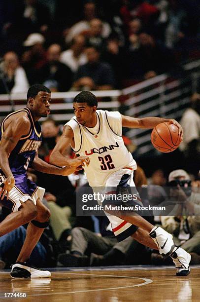 Guard Richard Hamilton of the University of Connecticut Huskies drives against guard Deon Luton of the Washington Huskies during the Great Eight...
