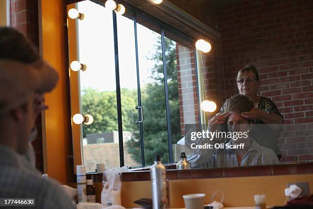 Wig maker Marian De Graef fixes the wig on Jacques Imbrailo, who plays the character Billy Budd, at Glyndebourne opera house before a production of...