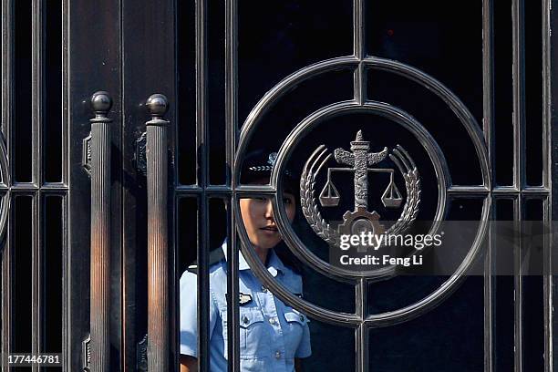 Chinese police woman looks out the gate of the Jinan Intermediate People's Court on August 23, 2013 in Jinan, China. Ousted Chinese politician Bo...