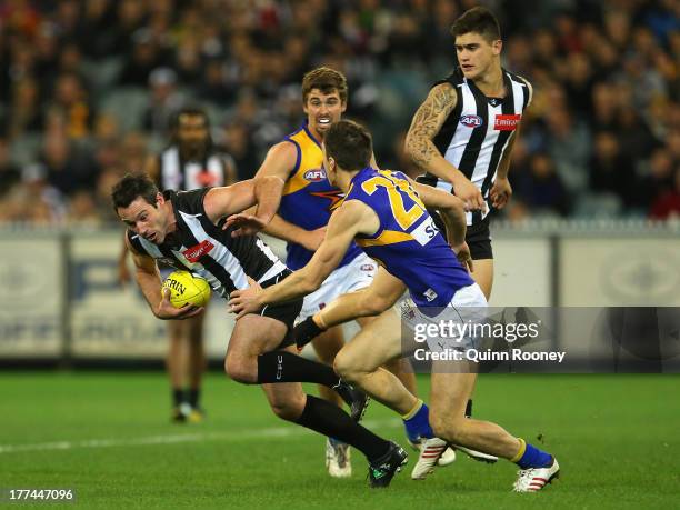 Alan Didak of the Magpies attempts to fend off a tackle by Sam Butler of the Eagles during the round 22 AFL match between the Collingwood Magpies and...