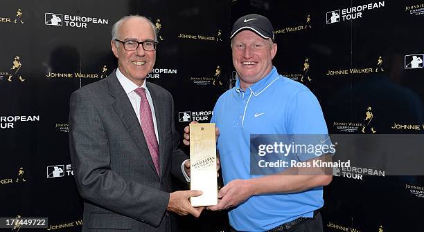 Richard Finch of England is presented with a bottle whiskey by Patrick Elsmie, Managing Director of The Gleneagles Hotel for his hole in-one prize...