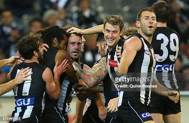 Alan Didak of the Magpies is congratulated by team mates after kicking a goal during the round 22 AFL match between the Collingwood Magpies and the...