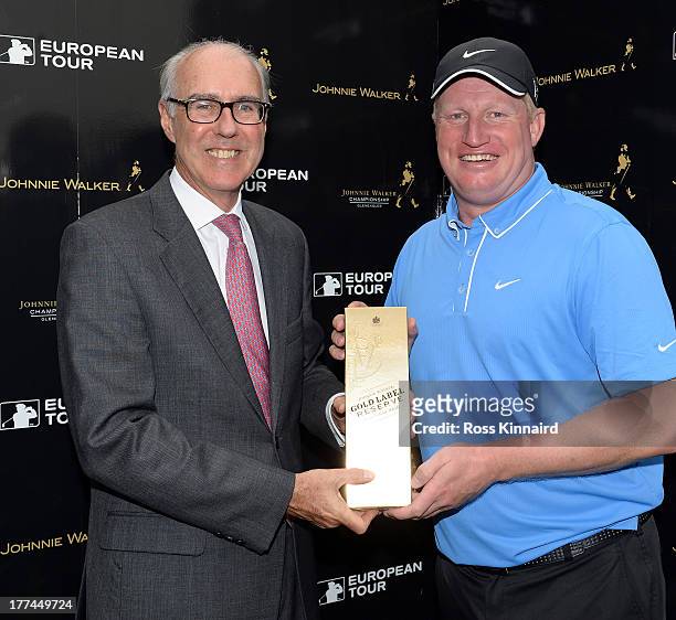 Richard Finch of England is presented with a bottle whiskey by Patrick Elsmie, Managing Director of The Gleneagles Hotel for his hole in-one prize...