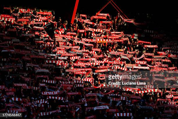 General view inside the stadium as a ray of sunlight illuminates the 1.FC Union Berlin fans holding scarves prior to the Bundesliga match between 1....